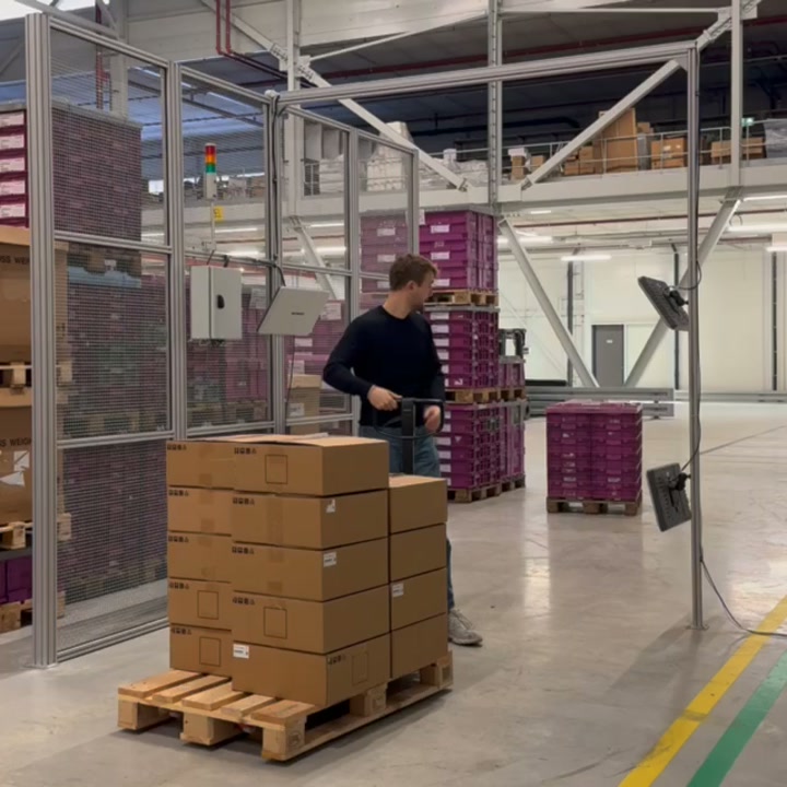 An employee moves a pallet of boxes through a fixed RFID read zone.
